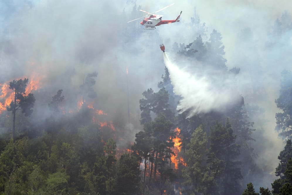 Ein Löschhubschrauber schüttet Wasser auf einen Waldbrand in Spanien: Am Sonntag droht eine neue Hitzewelle, die Feuer anzufachen.