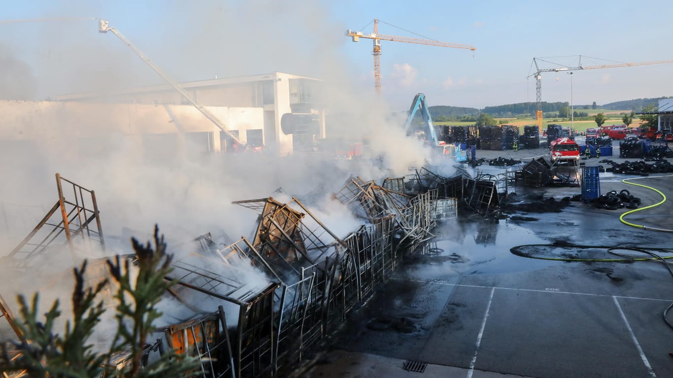 Auf dem Gelände eines Reifengroßhändlers löschen Einsatzkräfte der Feuerwehr den Brand: Ersten Schätzungen zufolge beläuft sich der entstandene Schaden auf mehrere Millionen Euro.
