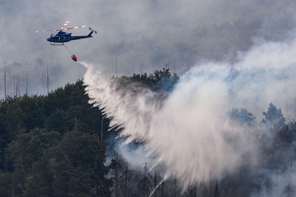 Mit einem Hubschrauber wird ein Waldbrand im tschechischen Nationalpark Böhmische Schweiz in Hrensko gelöscht: Das Feuer hat sich auf Sachsen ausgeweitet.