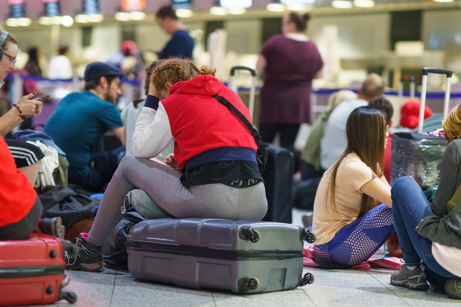 Passagiere warten am frühen Morgen am Frankfurter Flughafen auf eine Reisemöglichkeit. Wegen des Verdi-Warnstreiks hat die Lufthansa für Mittwoch nahezu ihren kompletten Flugplan abgesagt.