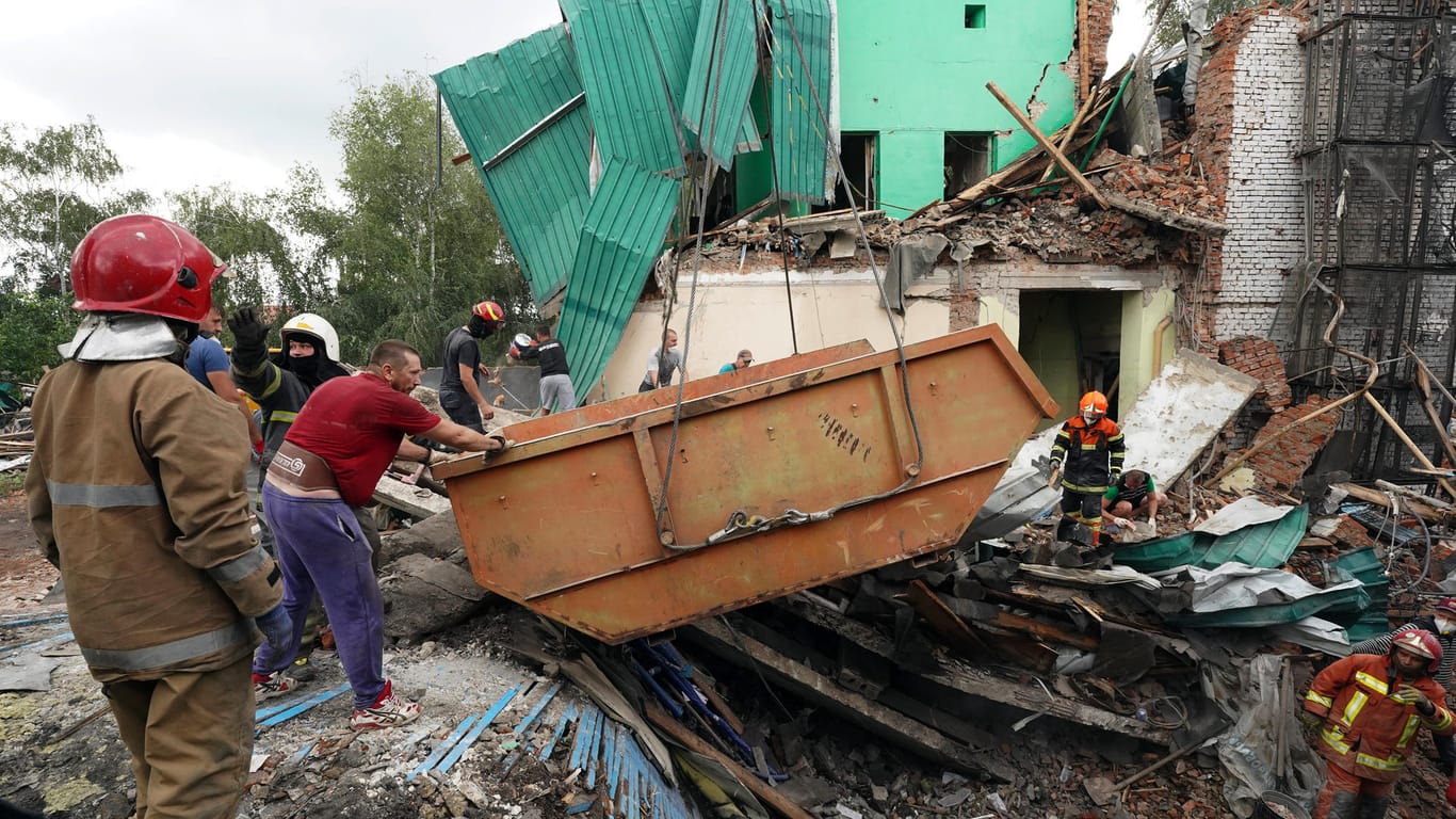 Einsatzkräfte entfernen Trümmer nach einem Raketenangriff des russischen Militärs in Tschuhujiw.