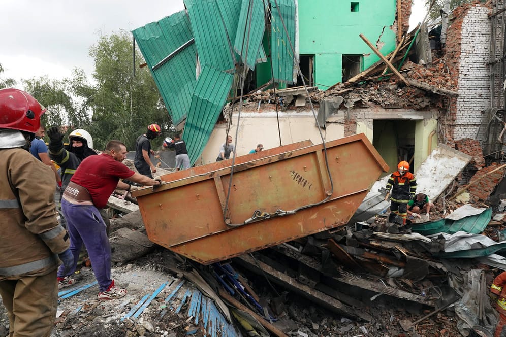 Einsatzkräfte entfernen Trümmer nach einem Raketenangriff des russischen Militärs in Tschuhujiw.