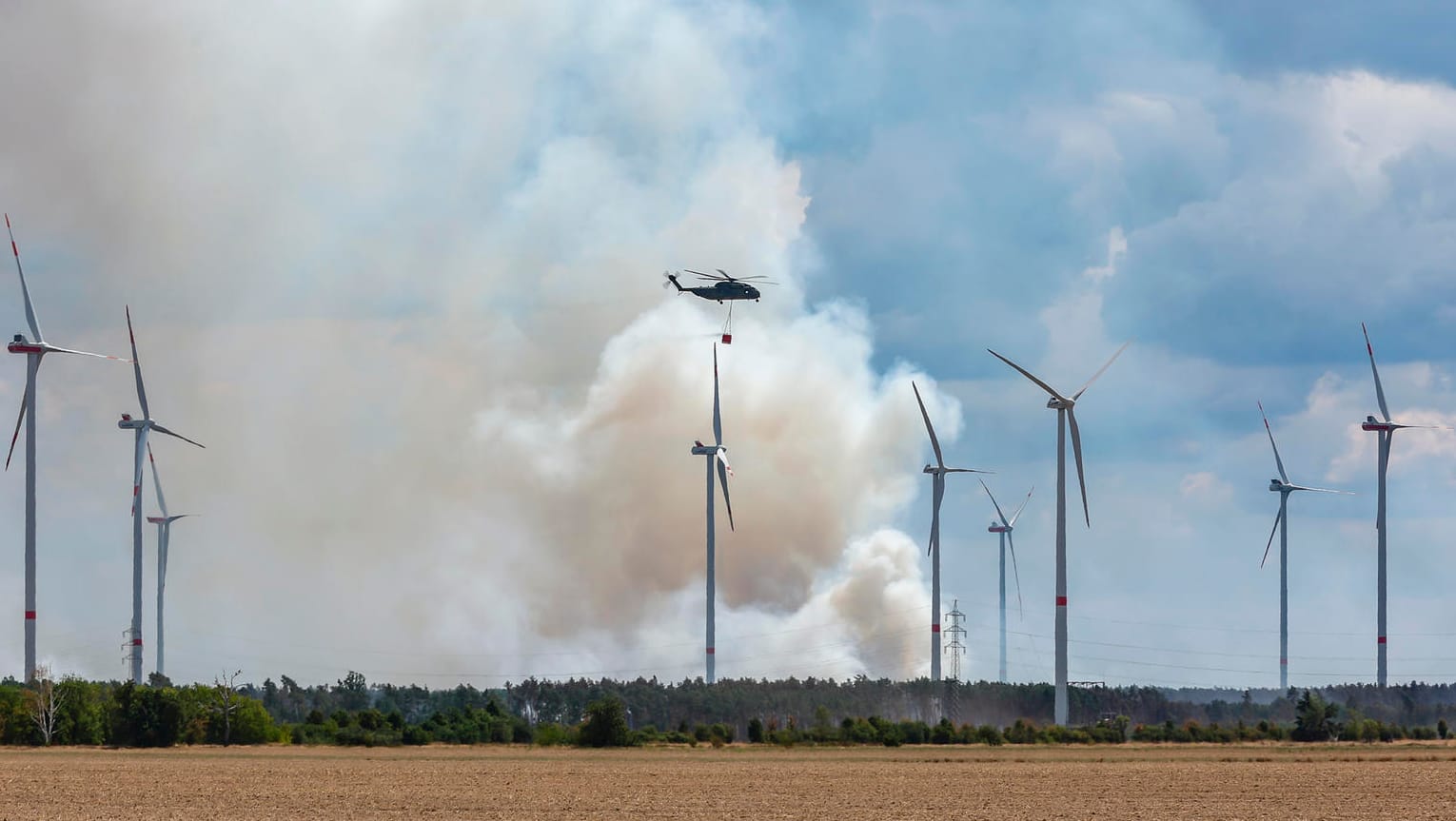 Bundeswehrhubschrauber mit Löschwasser im brandenburgischen Landkreis Elbe-Elster: Die Feuerwehr kämpft weiter gegen einen großen Waldbrand.