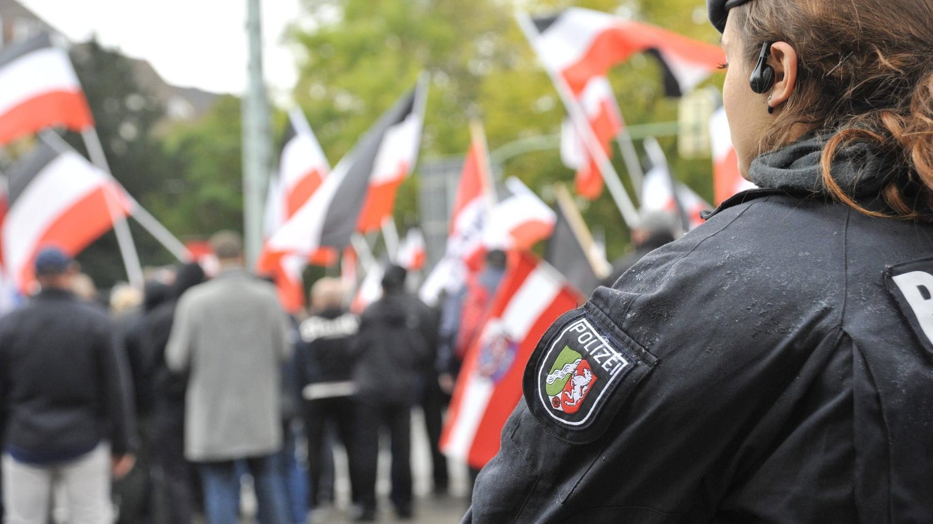 Feature / Symbol: Polizistin bei einer Neonazi-Demo 11/19 thg Polizistin beobachtet Neonazi-Demo der Partei Die Rechte f