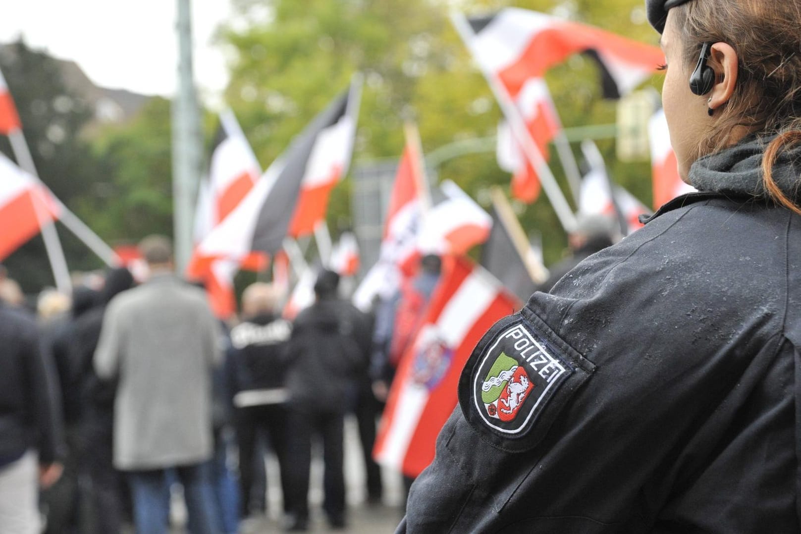 Feature / Symbol: Polizistin bei einer Neonazi-Demo 11/19 thg Polizistin beobachtet Neonazi-Demo der Partei Die Rechte f