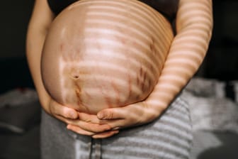 Eine Schwangere hält ihren Bauch.