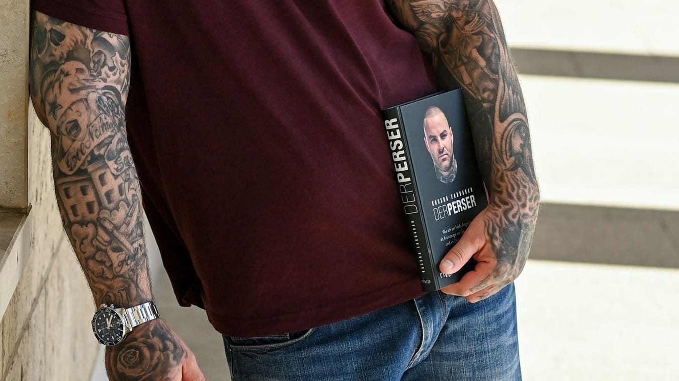 Kassra Zargaran hält sein Buch "Der Perser" in der Hand: Darin berichtet er auch über seine Zeit bei dem berüchtigten Rockerclub Hells Angels.
