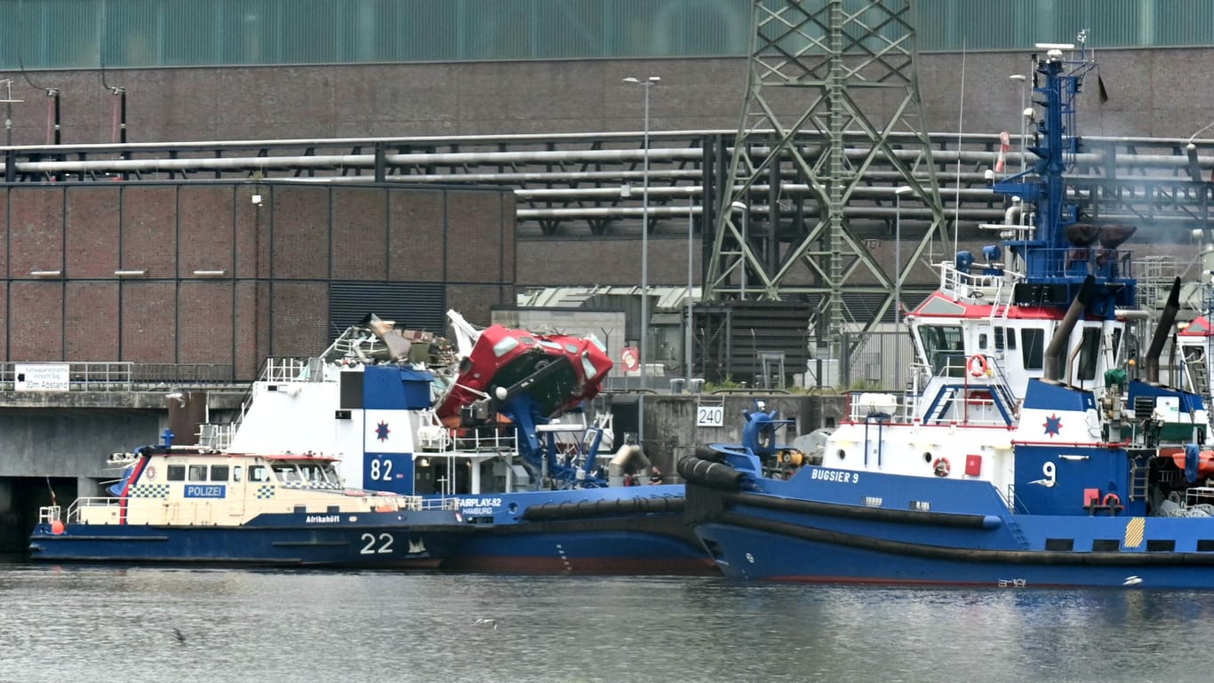 Der Schlepper liegt neben einem Polizeischiff im Hafen.