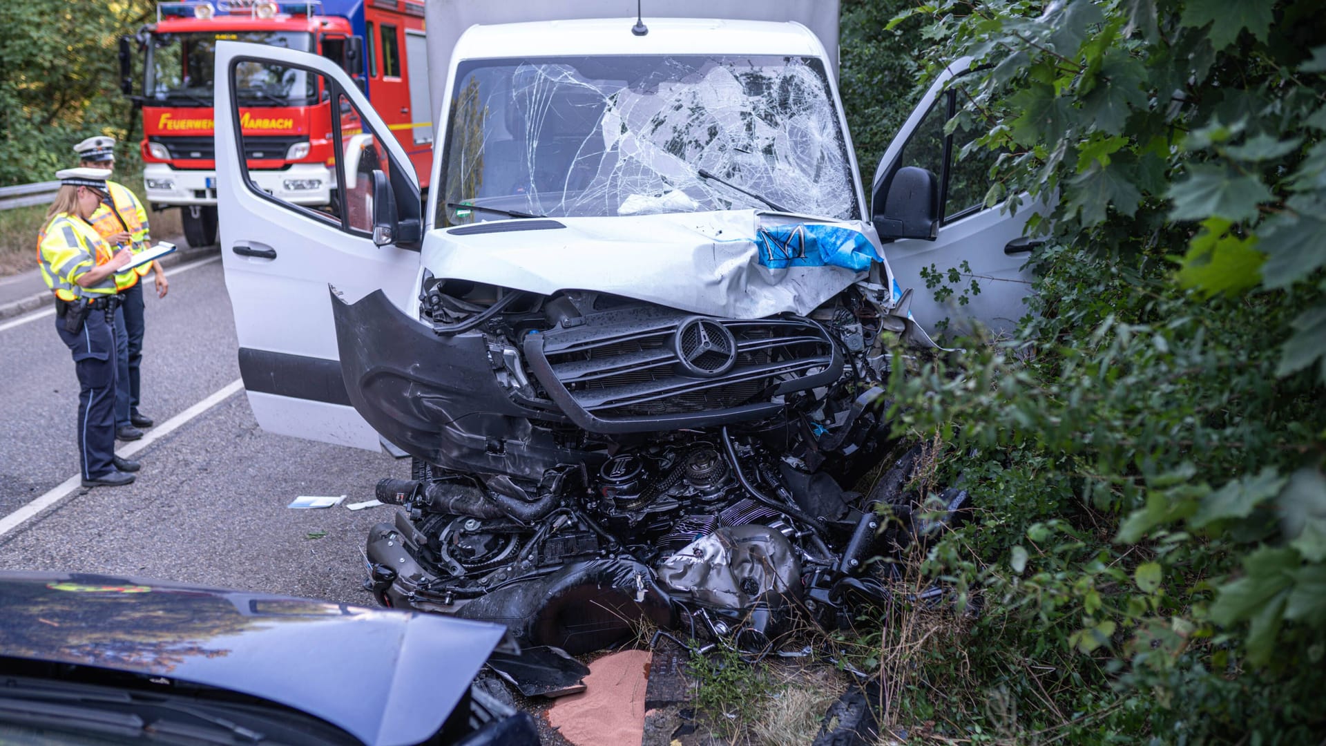 Der Unfallwagen mit dem zerstörten Motorrad: Einsatzkräfte sind weiterhin vor Ort im Einsatz.