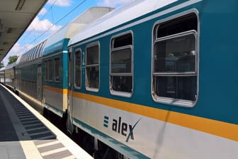 Eine Regionalbahn von Alex steht am Bahnhof (Symbolbild): Dem Unternehmen brechen aktuell wegen Krankheit und Urlaub viele Mitarbeiter weg, weshalb Züge ausfallen.