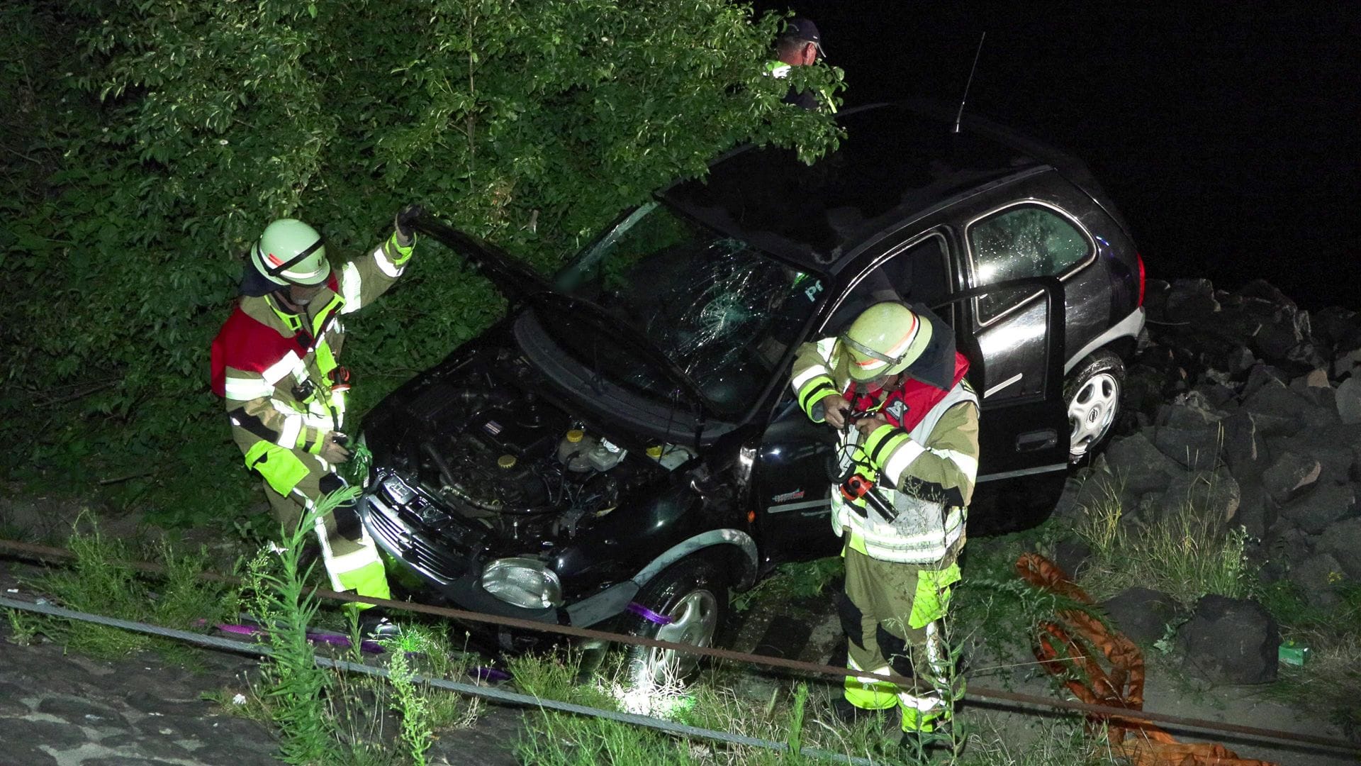 Feuerwehrleute neben dem geborgenen Fahrzeug: Eine Frau wurde bei dem Unfall leicht verletzt.