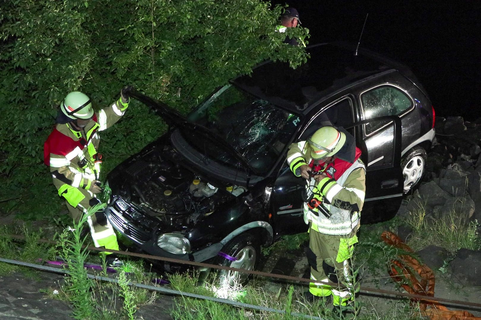 Feuerwehrleute neben dem geborgenen Fahrzeug: Eine Frau wurde bei dem Unfall leicht verletzt.