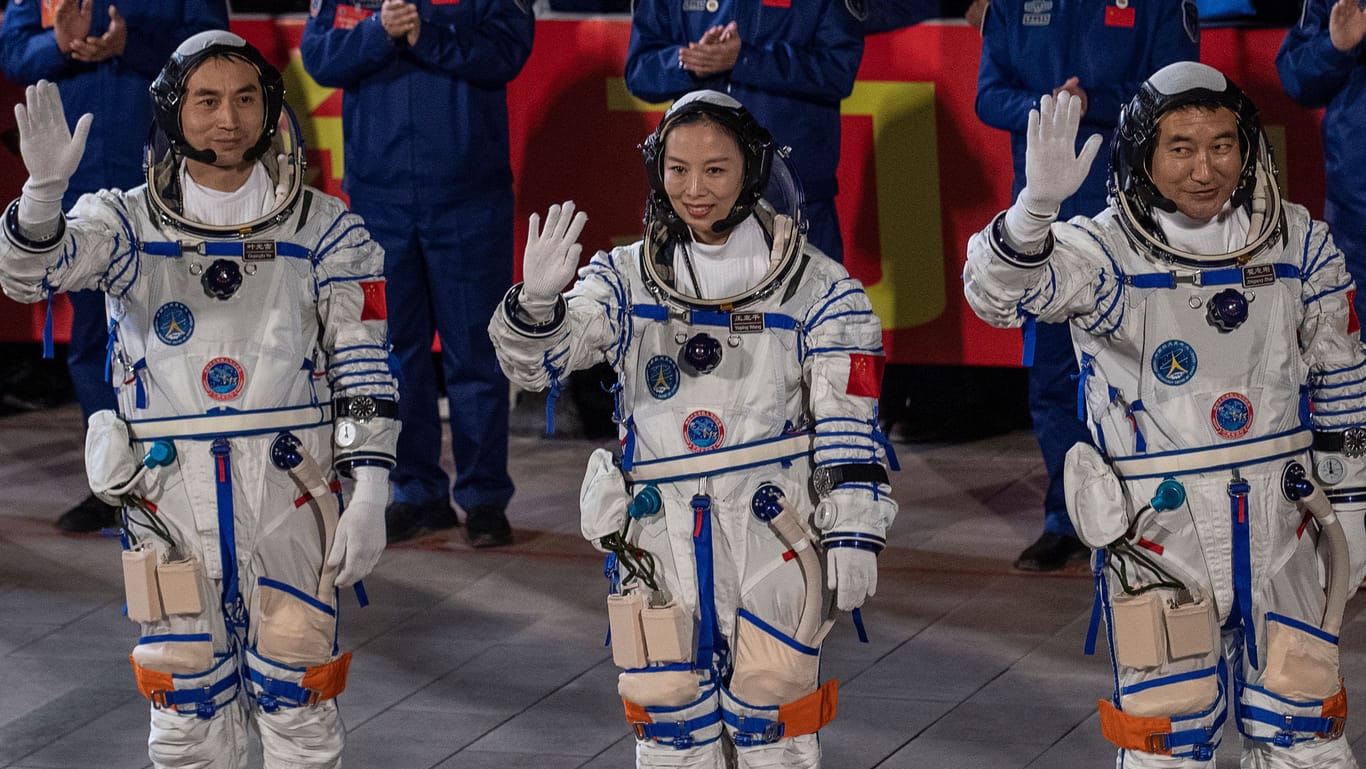 Chinese astronauts from China Manned Space Agency Wang Yaping, centre, Zhai Zhigang, and Ye Guangfu, left, wave as they take part in a pre-launch departure ceremony on October 15, 2021 at the Jiuquan Satellite Launch Center in Jiuquan, China.