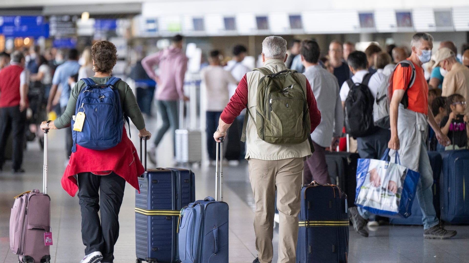 Passagiere gehen am Frankfurter Flughafen durch den Check-In-Bereich.