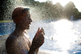 Eine Frühschwimmerin im Freibad Annabad unter einer Dusche (Symboldbild). Die Stadt Hannover plant das Duschwasser in städtischen Schwimmbädern nicht mehr zu beheizen.