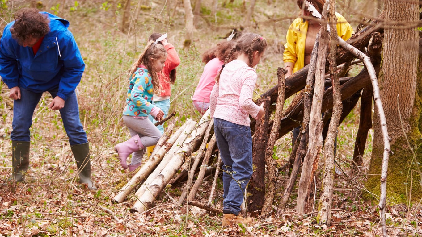 Kinder spielen im Wald mit Holz (Symbolbild): Das Camp musste abgebrochen werden.