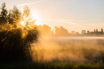 Die aufgehende Sonne taucht Nebel in warmes Licht (Hannover). Der Deutsche Wetterdienst sagt für die nächsten Tage eine Hitzewelle voraus.