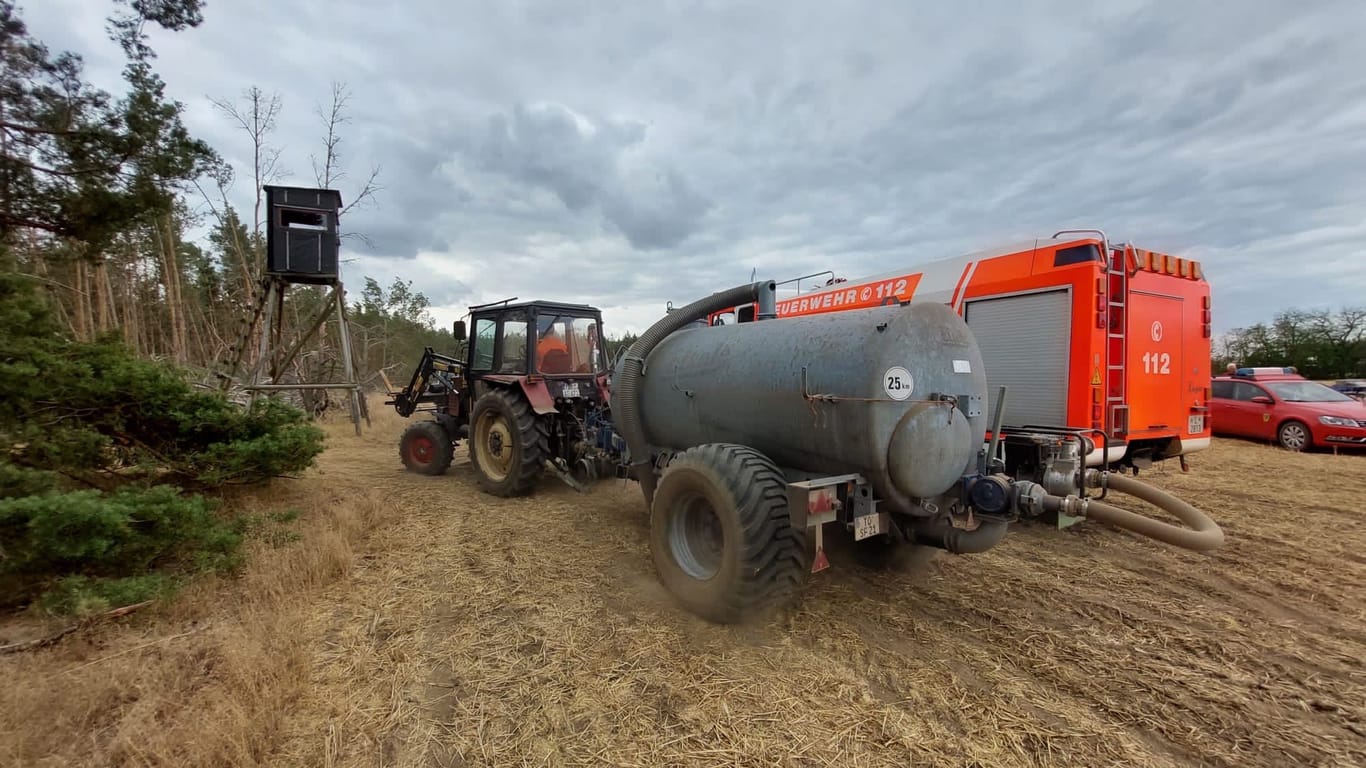 Löschfahrzeug wird bei Kötten mit frischen Wasser befüllt: Bauern und der Staatsbetrieb Sachsenforst unterstützen die Löscharbeiten mit Wasserlieferungen.