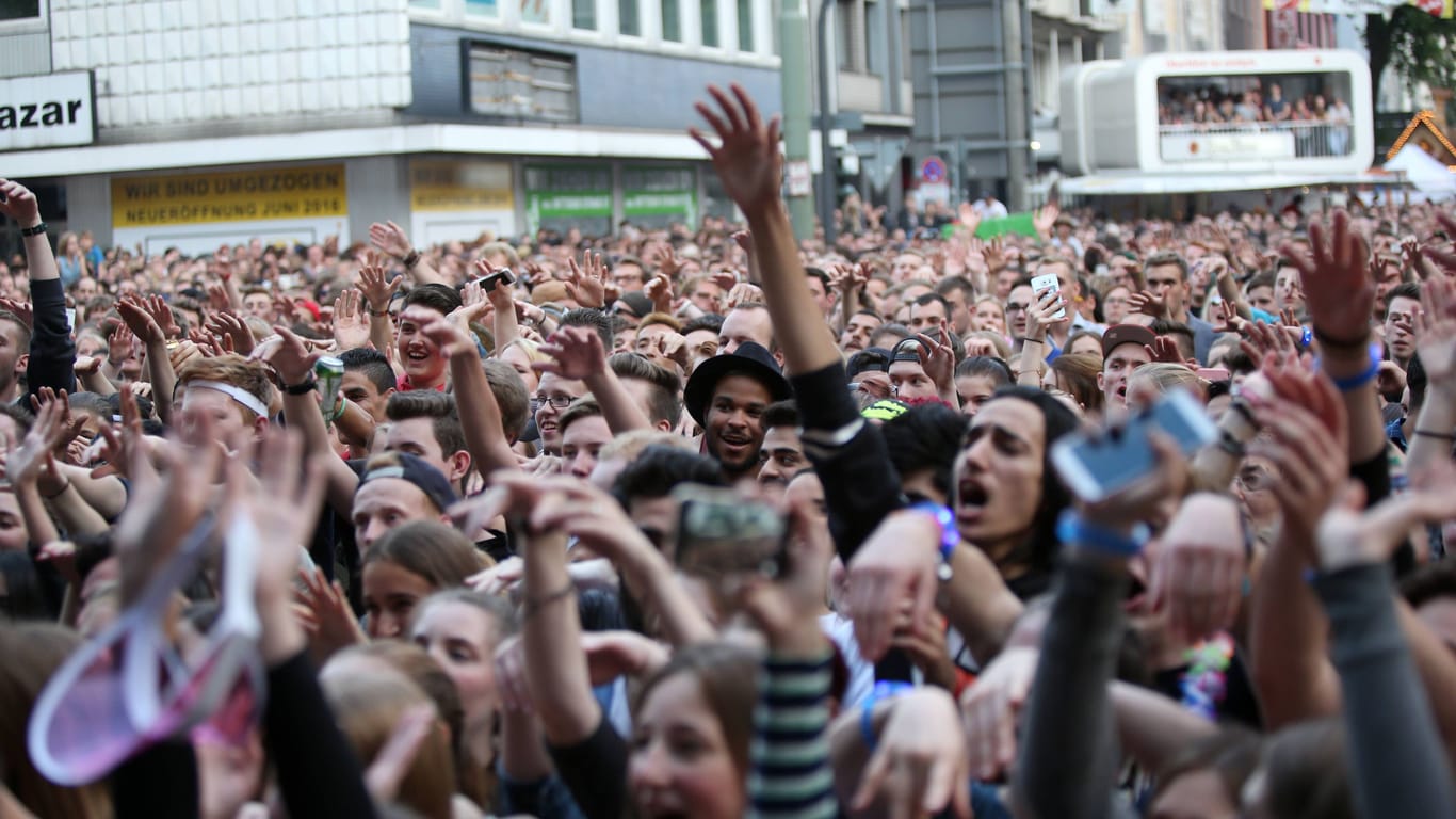 Besucher strecken die Hände hoch (Archivbild): Das Bochum Total ist ein Festival mitten in der Stadt.