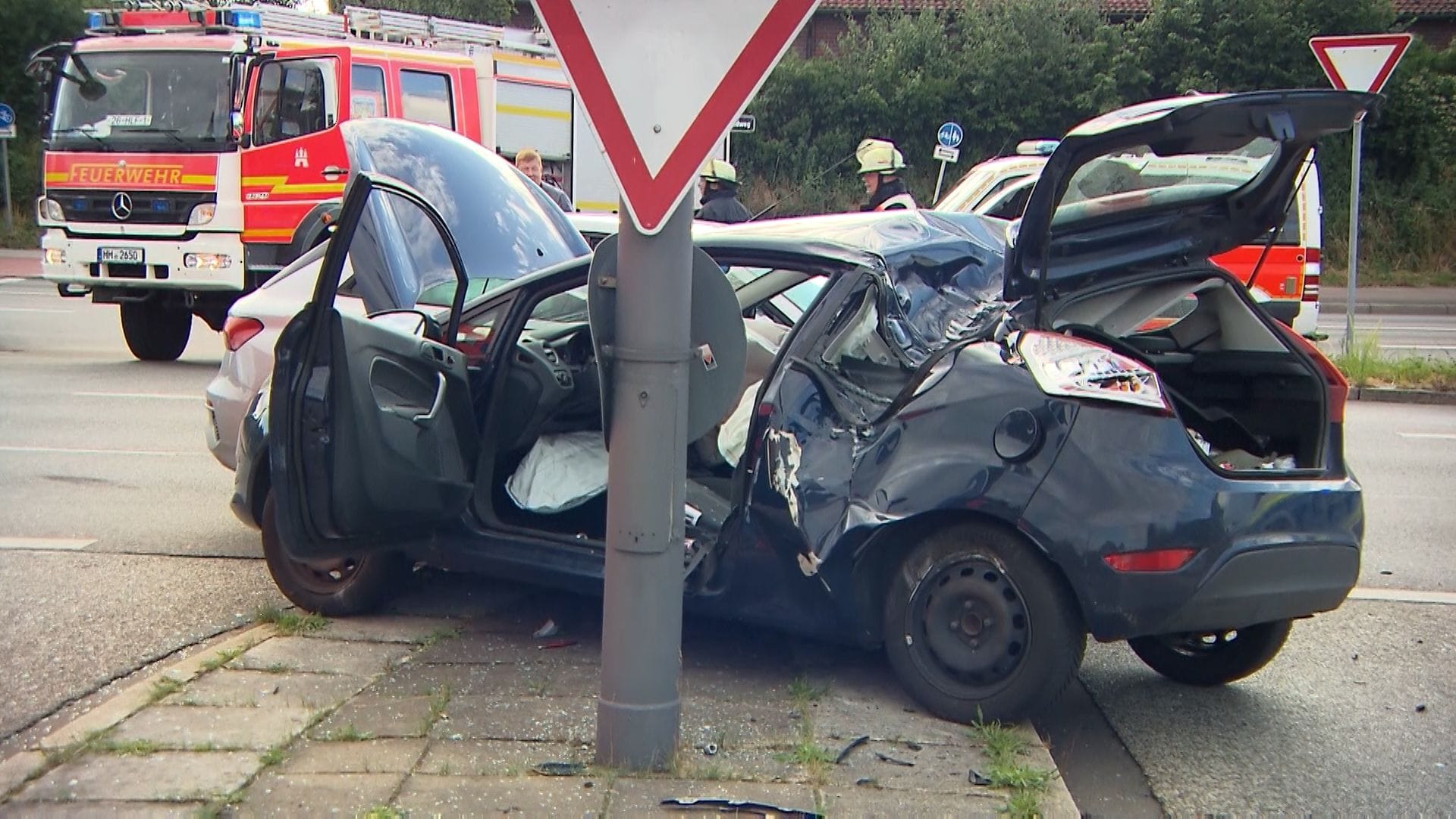 Ein zerstörter Pkw steht auf einer Verkehrsinsel. Die Insassen mussten von Rettungskräften behandelt werden. Ein zerstörter Pkw steht auf einer Verkehrsinsel. Die Insassen mussten von Rettungskräften behandelt werden.
