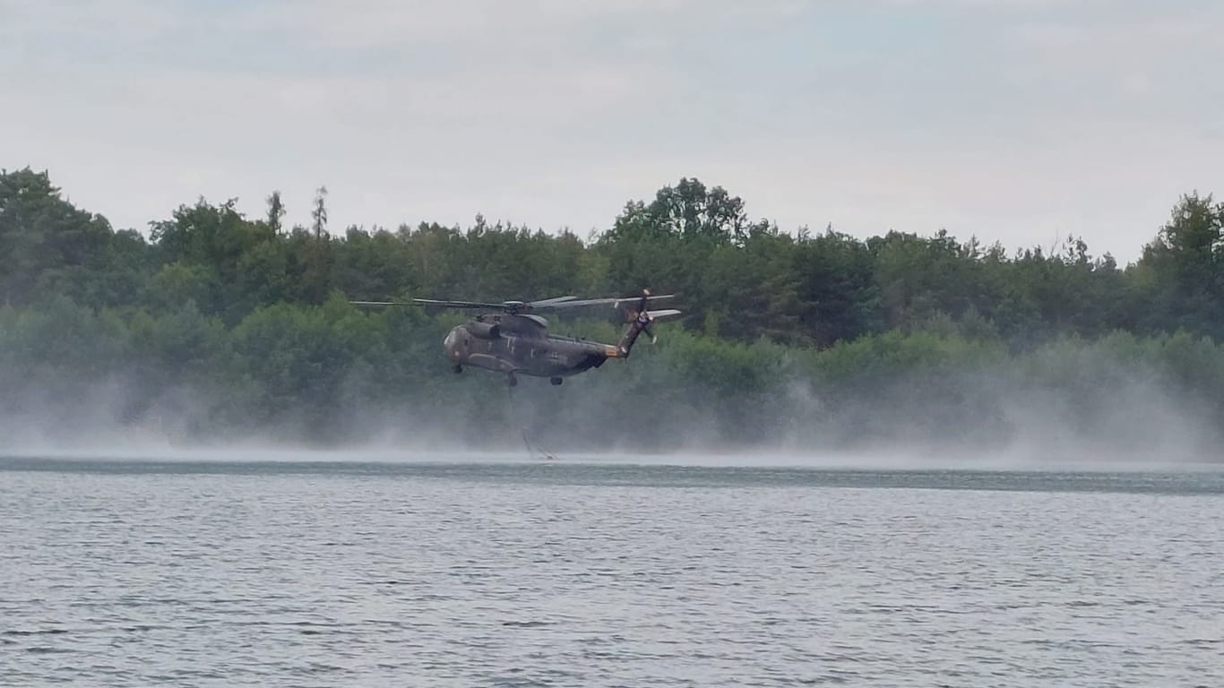 Bundeswehrhubschrauber am Kiebitzsee bei Falkenberg: Die Helikopter fliegen im Minutentakt über die Köpfe der Menschen ins Brandgebiet.