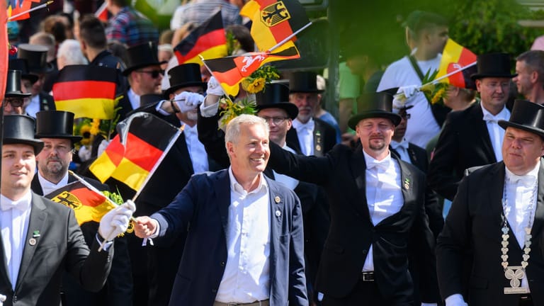 Alt-Bundespräsident Christian Wulff läuft mit einer Deutschland-Flagge mit dem Collegium ehemaliger Bruchmeister der Hauptstadt Hannover e.V. beim Schützenausmarsch.