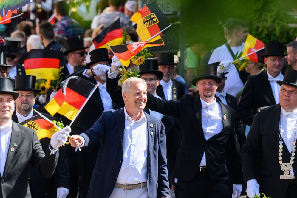 Alt-Bundespräsident Christian Wulff läuft mit einer Deutschland-Flagge mit dem Collegium ehemaliger Bruchmeister der Hauptstadt Hannover e.V. beim Schützenausmarsch.