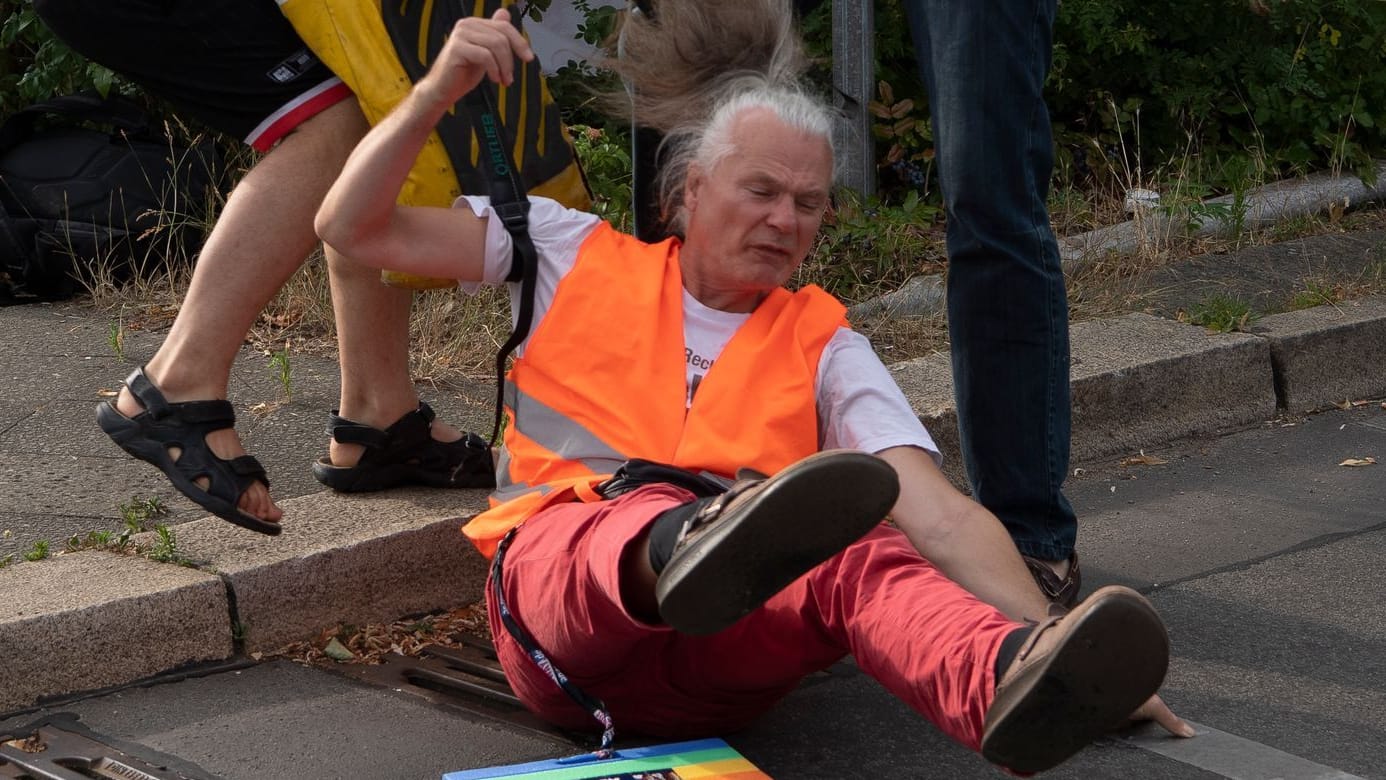 Der verletzte Klima-Demonstrant: Ein DHL-Mitarbeiter und ein Autofahrer zogen ihn bereits zuvor von der Straße.