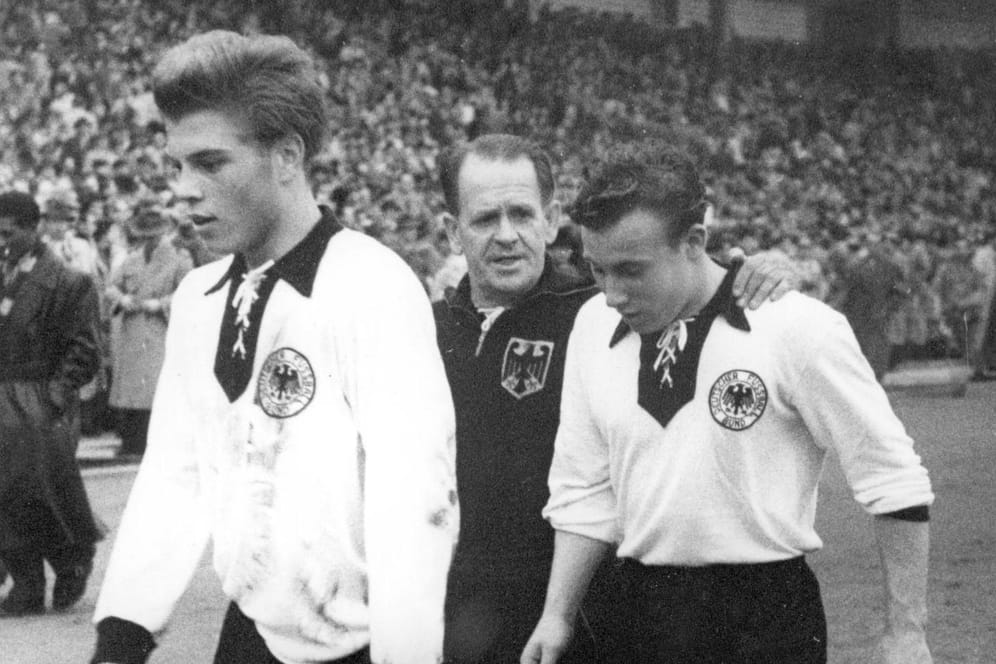 Klaus Stürmer (l.) beim gemeinsamen Länderspieldebüt mit Uwe Seeler (r.) im Oktober 1954. In der Mitte: Bundestrainer Sepp Herberger. Stürmer traf direkt bei der 1:3-Niederlage gegen Frankreich.
