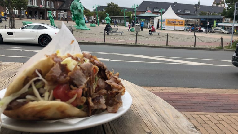 Der Sylt-Döner "mit allem" und "Kräuter-Knoblauch-Scharf": Genießen kann man ihn mit Blick auf den Westerländer Bahnhof.