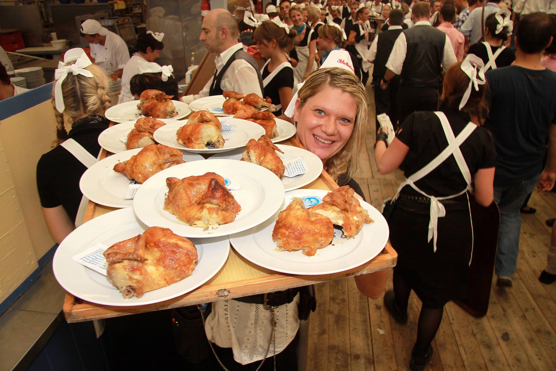 Oktoberfest-Kellnerin mit Hendl (Archivfoto): Die Herkunft der halben Hähnchen ist ein Politikum.