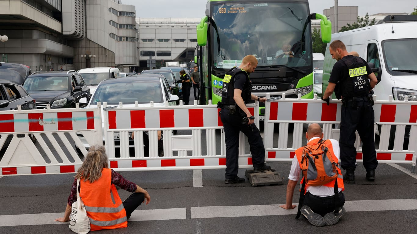 Polizisten errichten für den Klimaprotest Blockaden: Immer wieder kommt es zu Übergriffen auf die Klimaaktivisten.