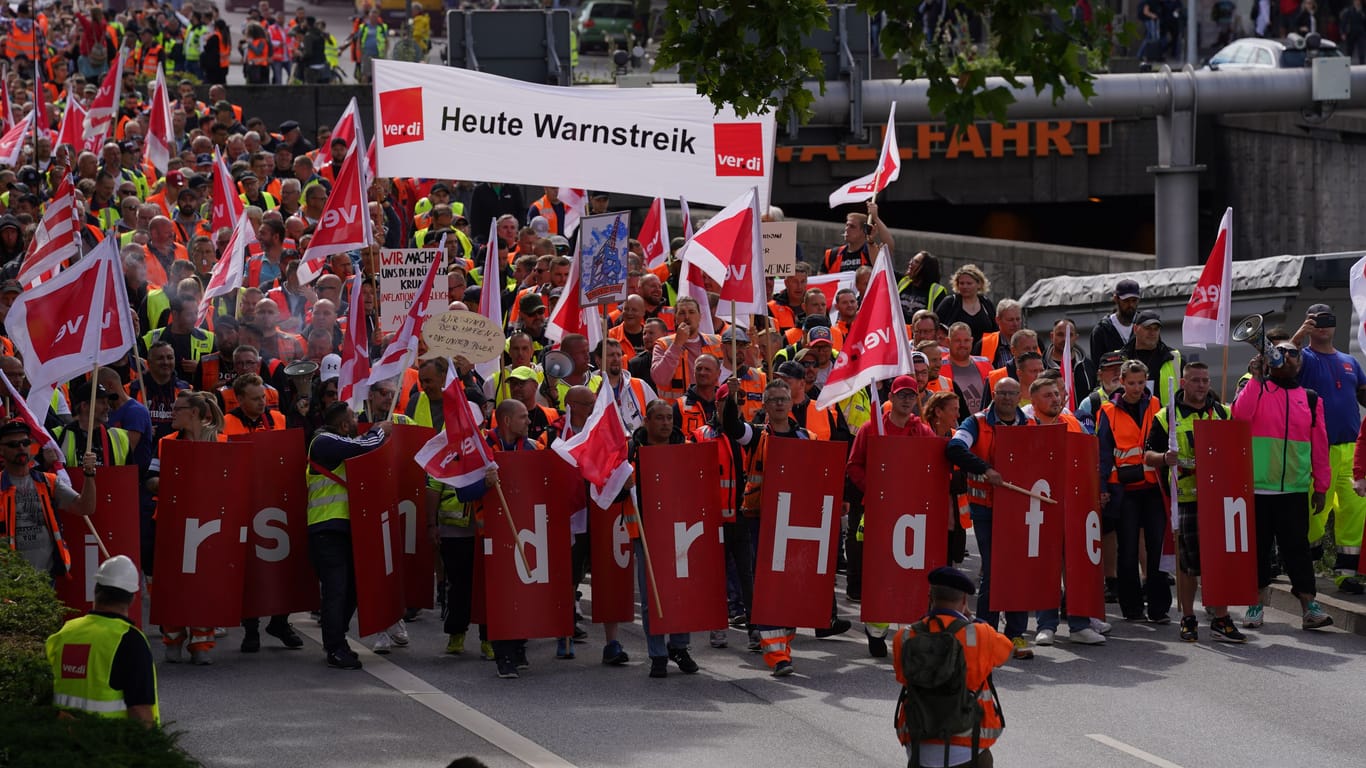 Hafen-Beschäftigte mit Verdi-Flaggen demonstrieren in der Innenstadt.