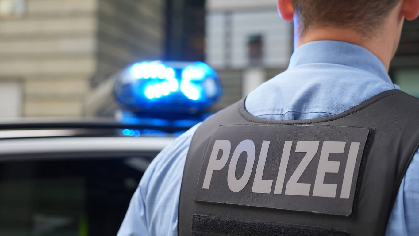 Ein Polizist steht an einem Streifenwagen (Symbolfoto): In Bremerhaven gingen vier Männer aufeinander los.