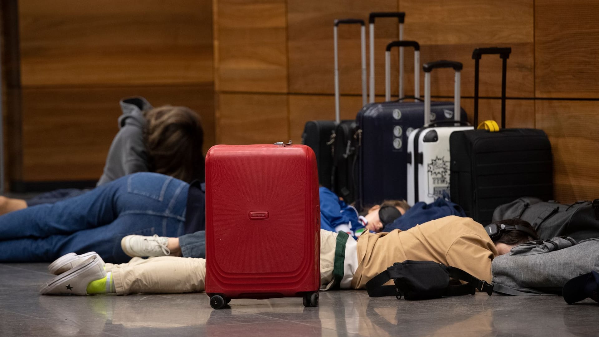 Auch am BER hat die Lufthansa alle Flüge gestrichen: Reisende liegen auf dem Boden und schlafen.