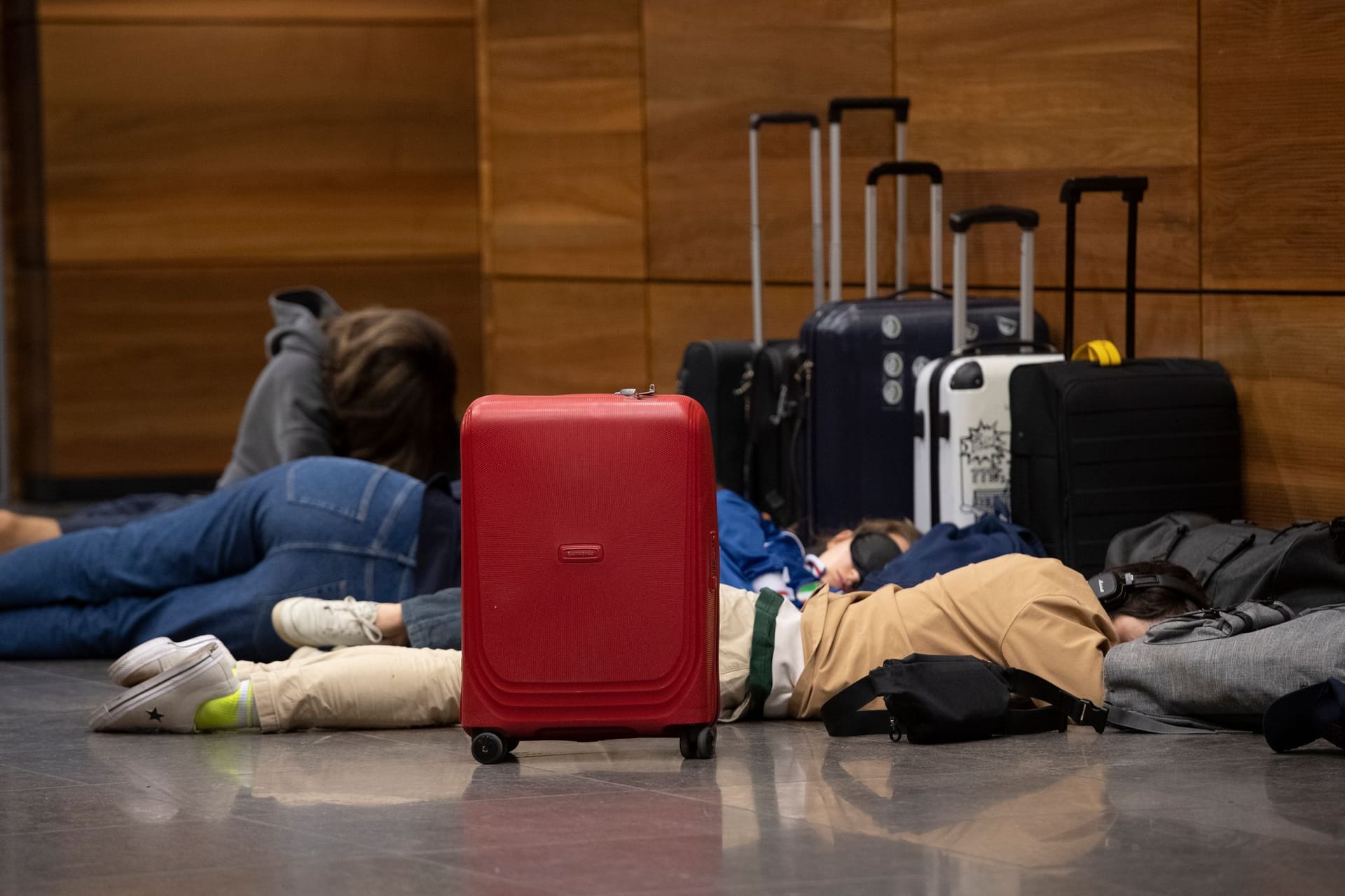 Auch am BER hat die Lufthansa alle Flüge gestrichen: Reisende liegen auf dem Boden und schlafen.