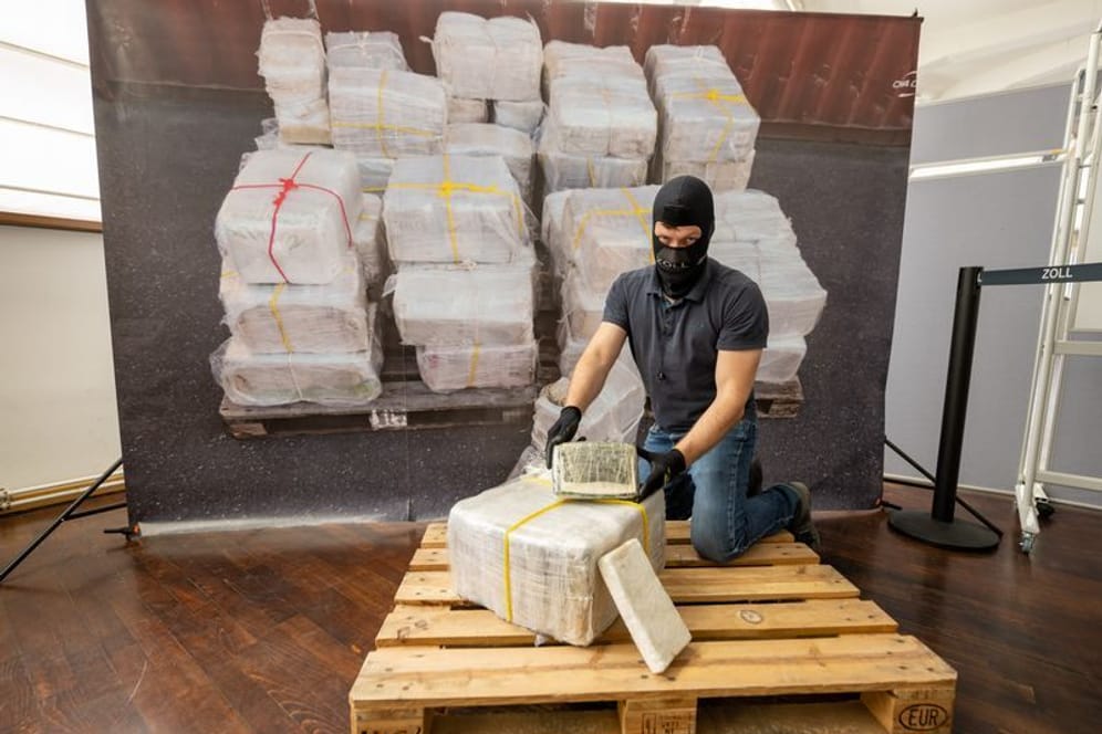 Ein Zollbeamter kniet vor einem Teil der zur bislang größten Einzelsicherstellung von Kokain in Bayern.