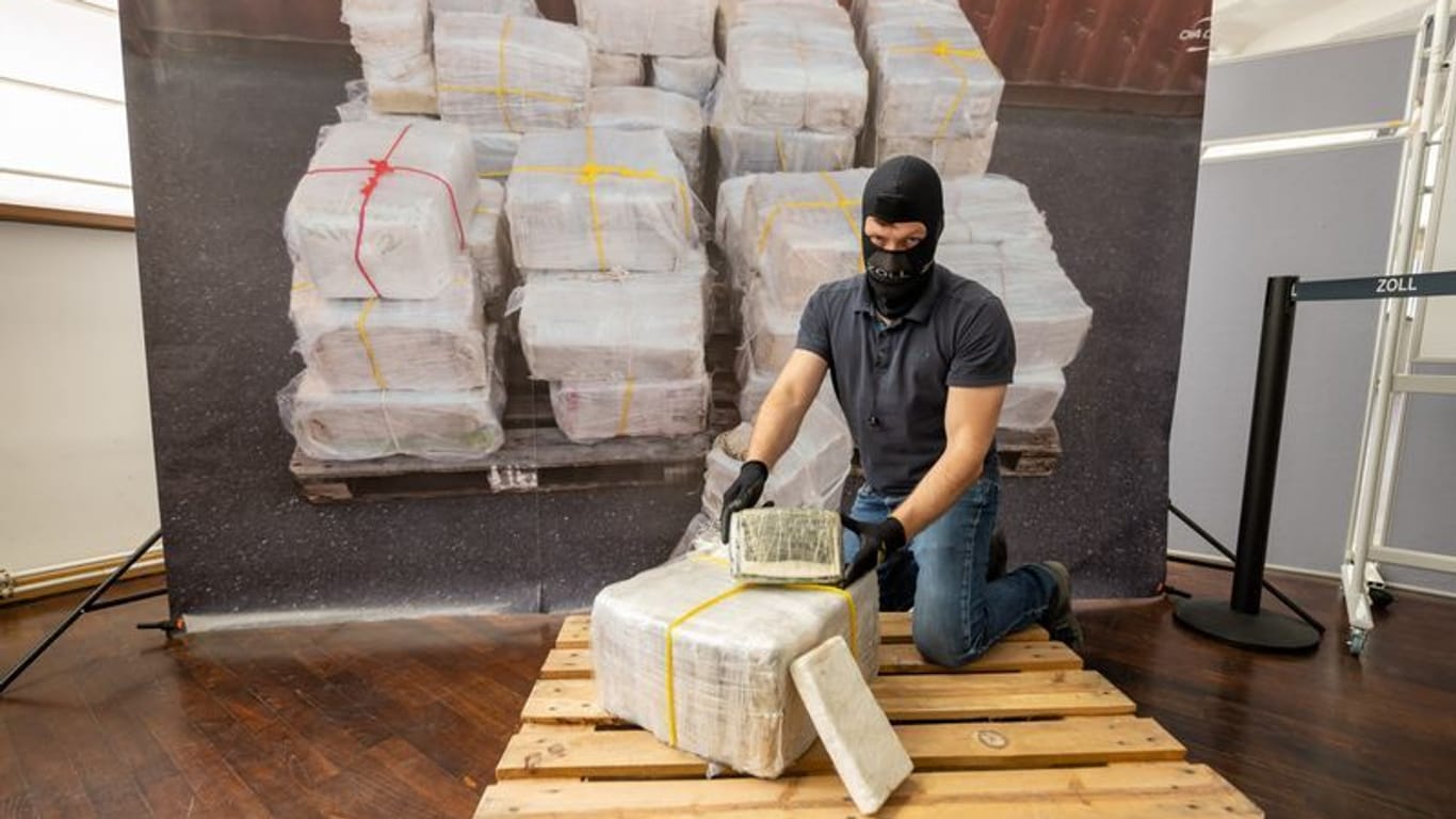 Ein Zollbeamter kniet vor einem Teil der zur bislang größten Einzelsicherstellung von Kokain in Bayern.