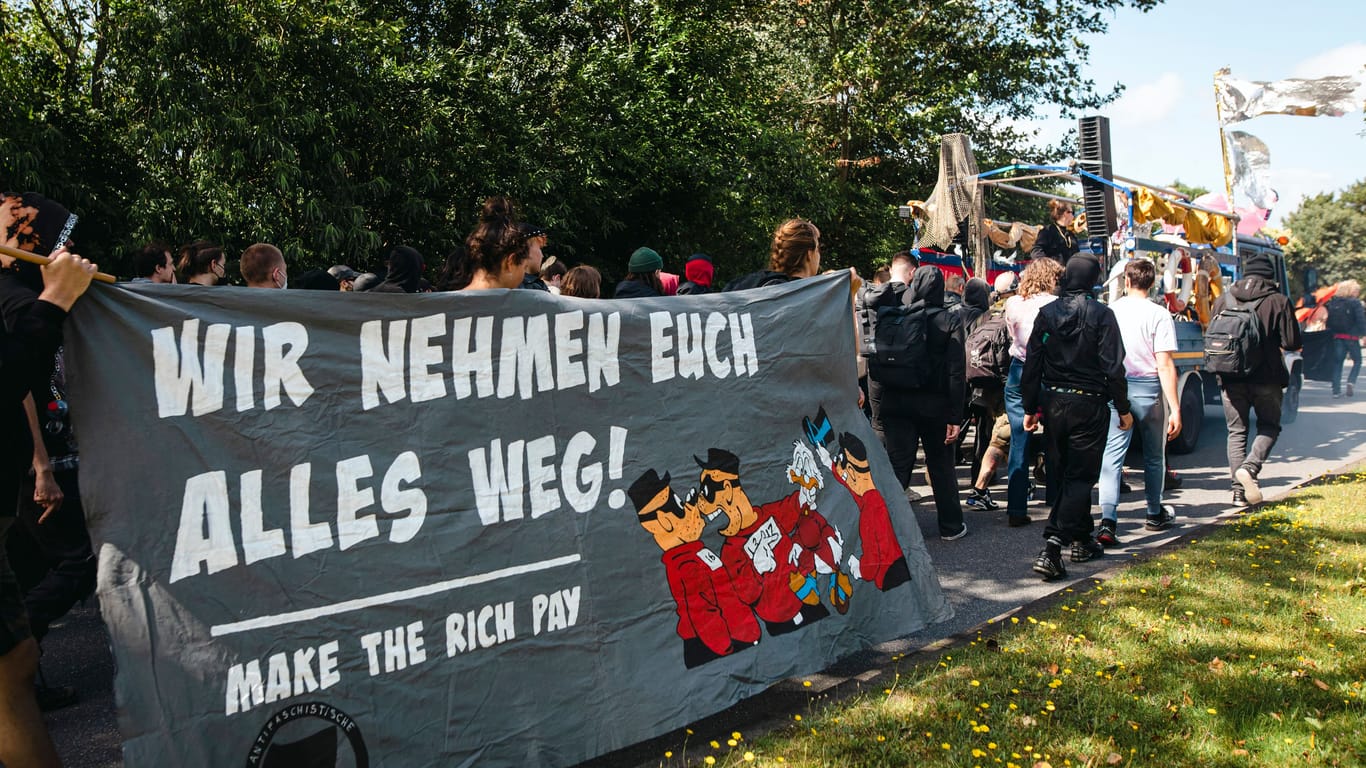 "Wir nehmen euch alles weg! Make The Rich Pay" steht auf einem Banner: Am Samstag zog eine linke Demonstration über die Insel.