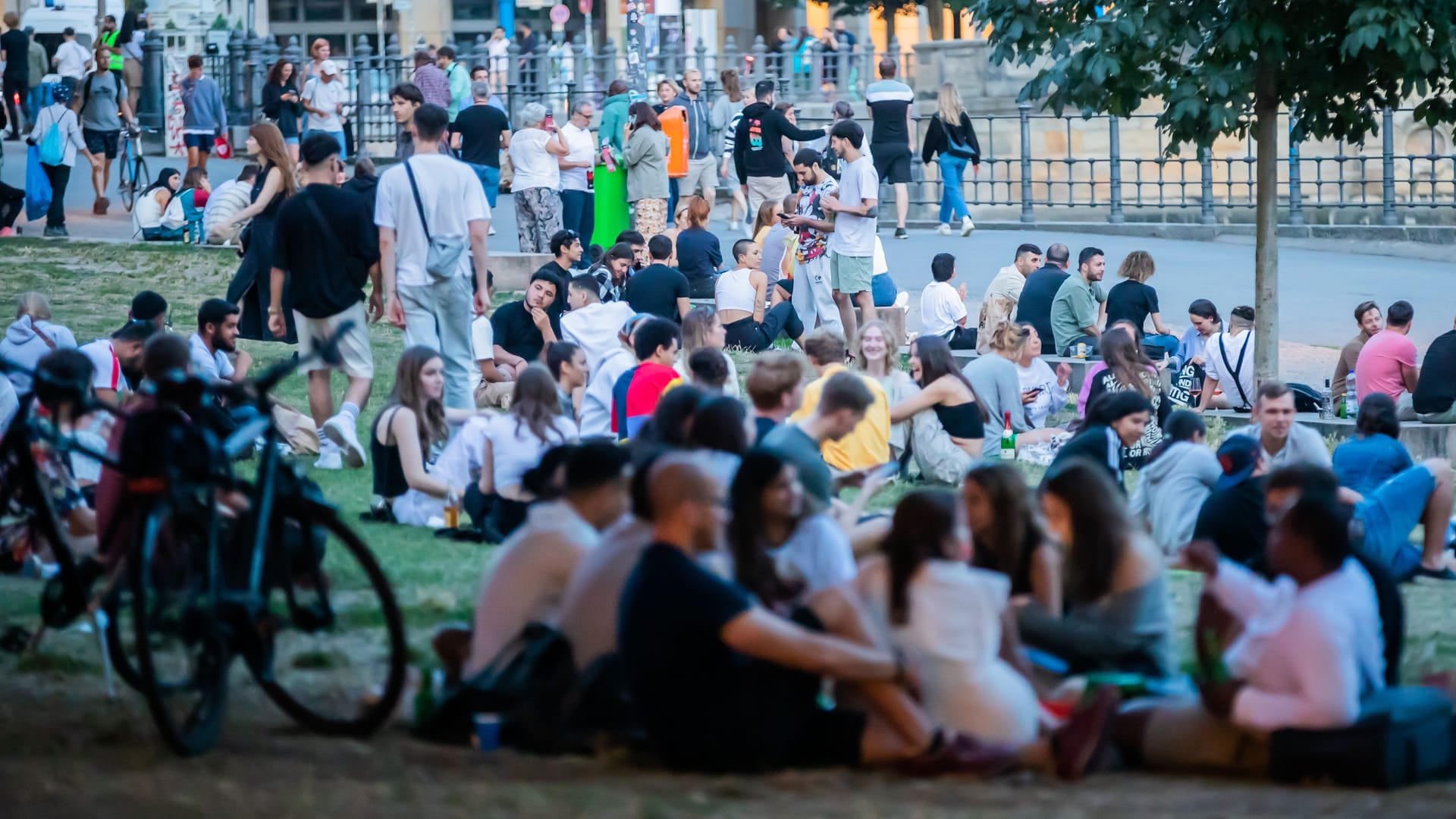 Menschen sitzen im James-Simon-Park: Immer wieder kam es hier in der Vergangenheit vor allem nachts zu Straftaten.