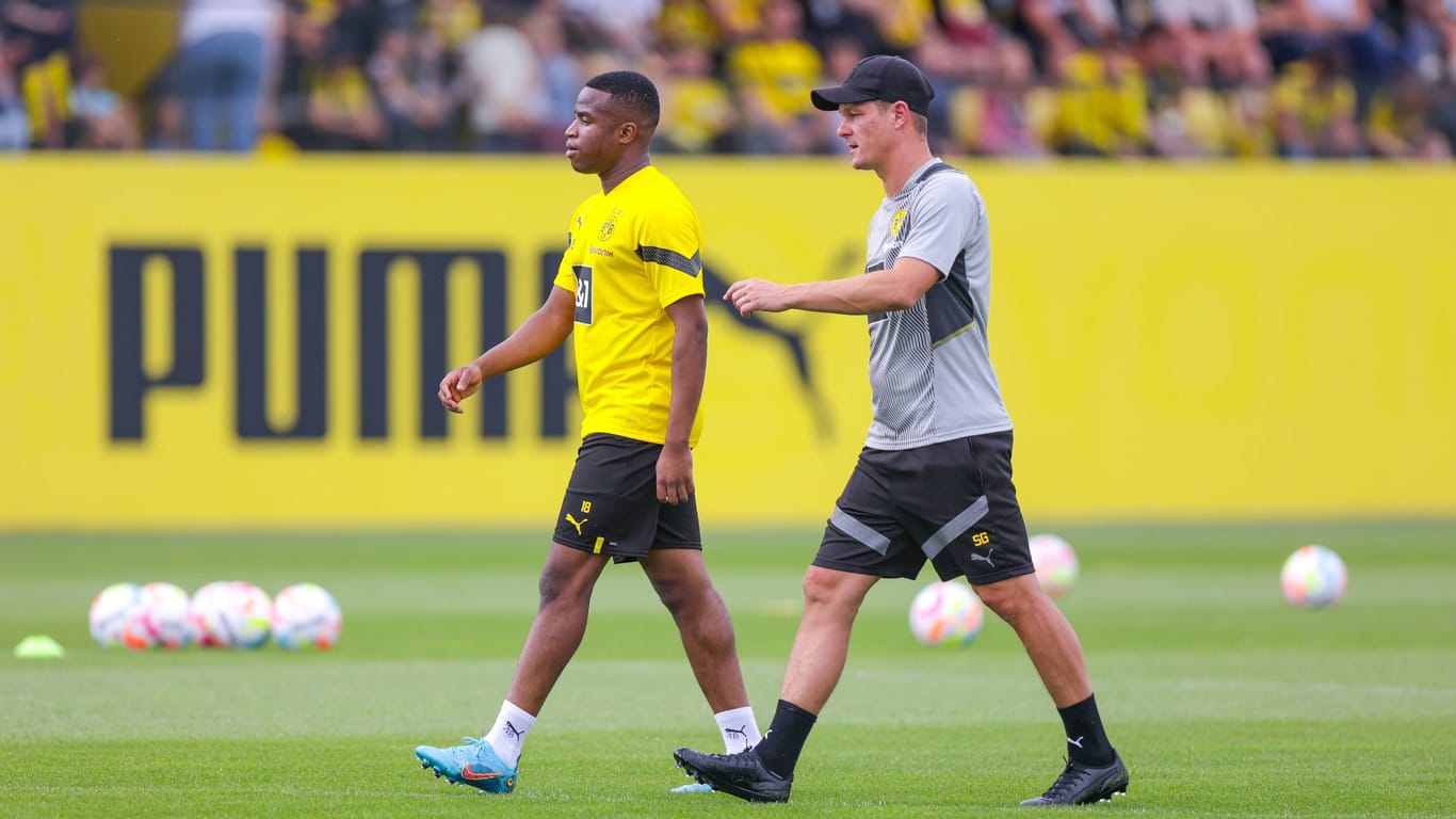 Youssoufa Moukoko (l.) & Co-Trainer Sebastian Geppert: Mit dem neuen Trainerteam des BVB kommt das Talent deutlich besser zurecht.