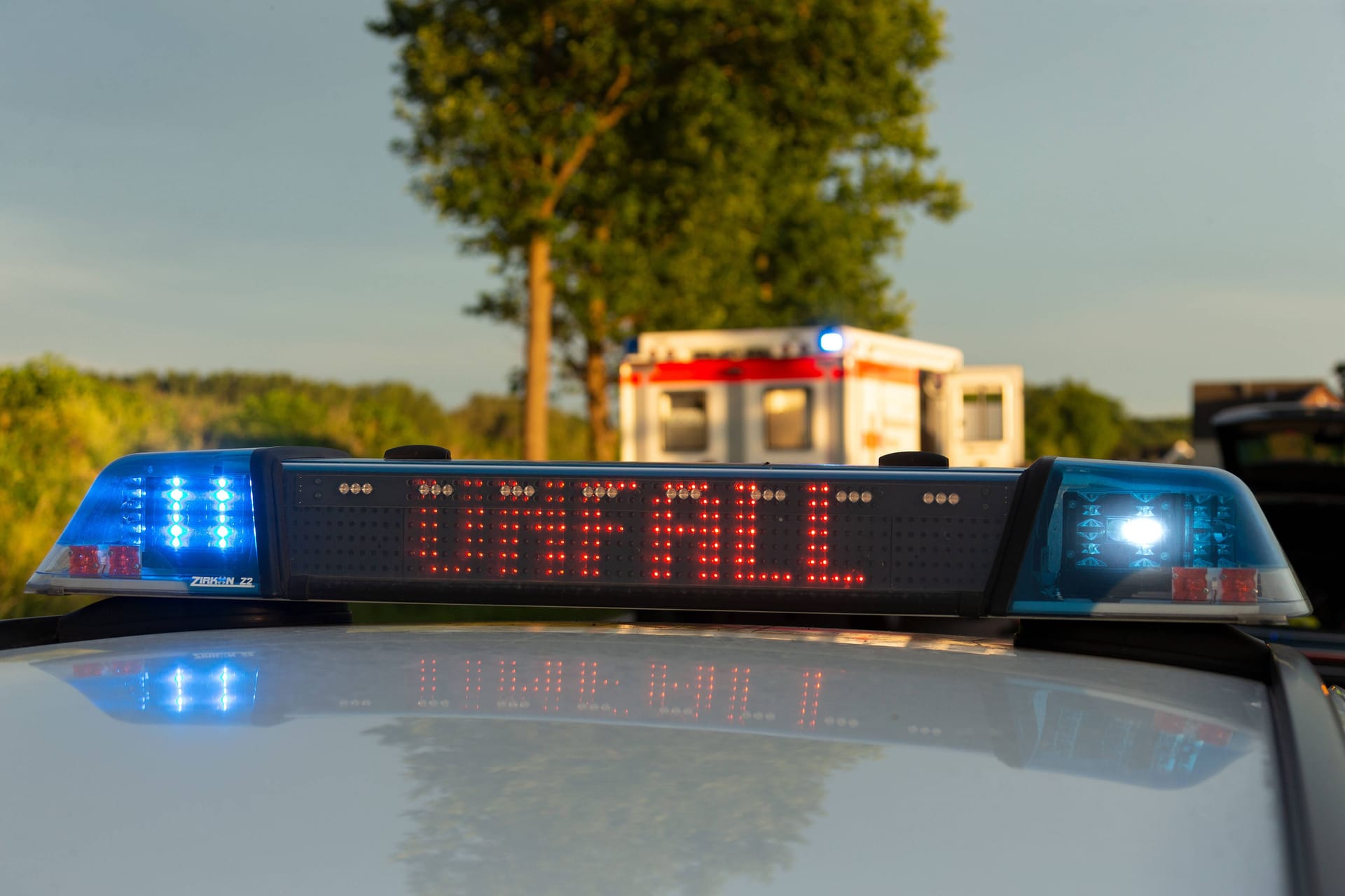 Ein Einsatzfahrzeug der Polizei steht mit Blaulicht und dem Schriftzug "Unfall" an einem Unfallort (Symbolbild): Der Vingster Ring ist derzeit noch gesperrt.