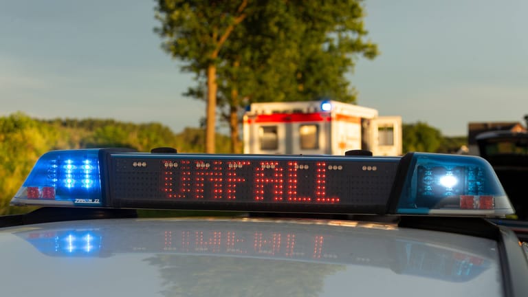 Ein Einsatzfahrzeug der Polizei steht mit Blaulicht und dem Schriftzug "Unfall" an einem Unfallort (Symbolbild): Der Vingster Ring ist derzeit noch gesperrt.