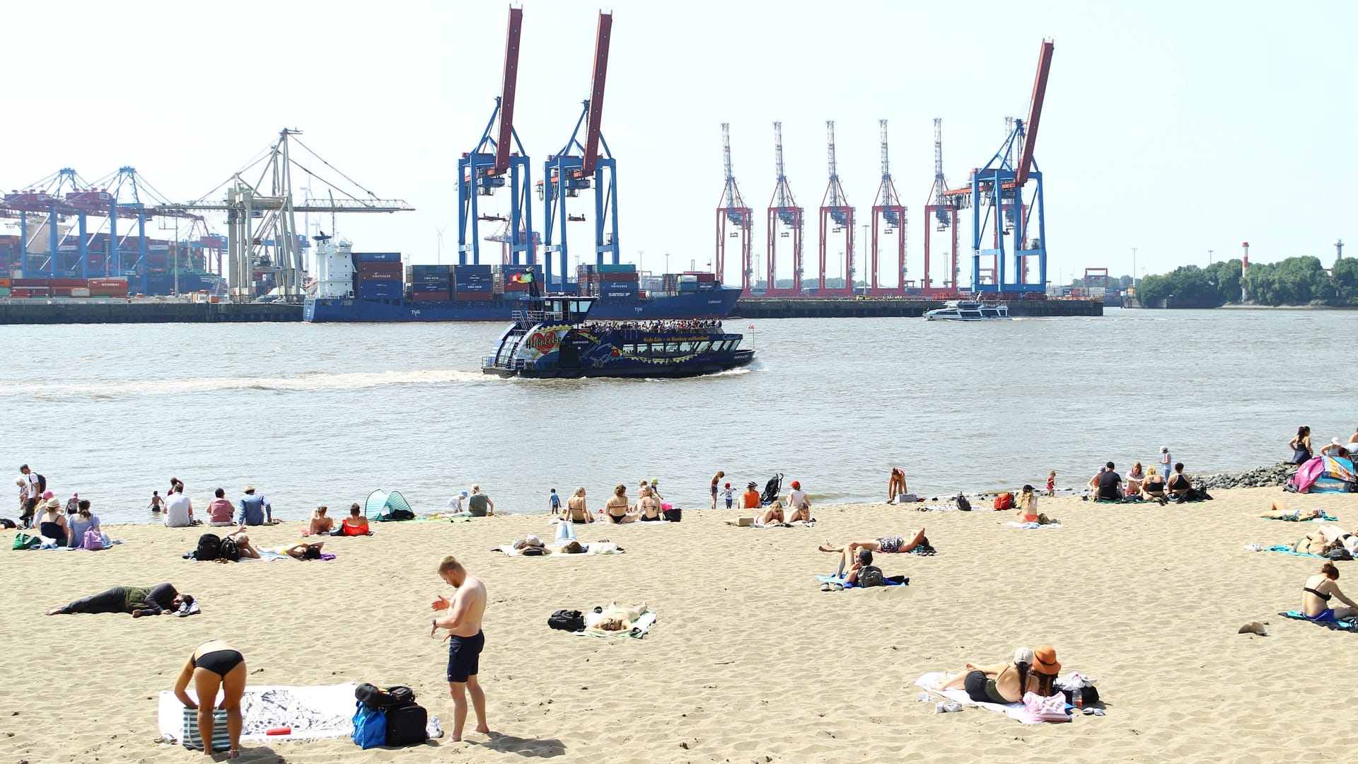 Passanten sonnen sich am Elbstrand bei Övelgönne (Archivbild).