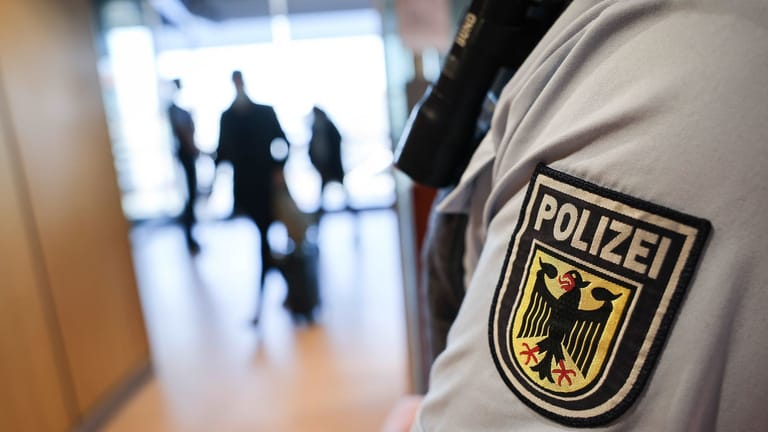 Ein Beamter der Bundespolizei kontrolliert Reisende am Flughafen (Symbolbild): Bei den Kontrollen am Stuttgarter Flughafen sind den Beamten gleich drei Straftäter aufgefallen.