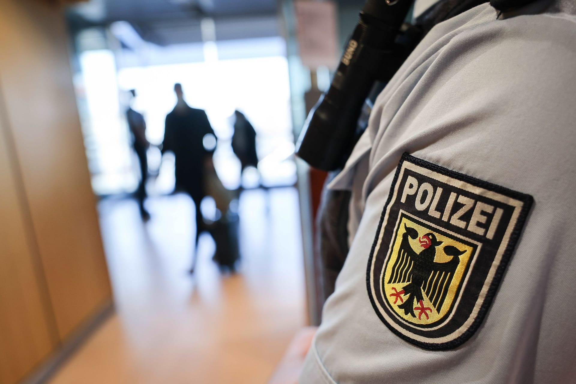 Ein Beamter der Bundespolizei kontrolliert Reisende am Flughafen (Symbolbild): Bei den Kontrollen am Stuttgarter Flughafen sind den Beamten gleich drei Straftäter aufgefallen.