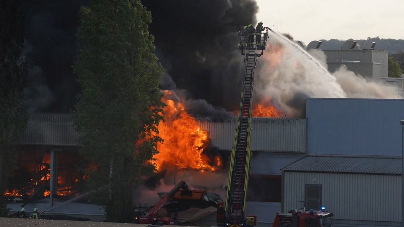 Einsatzkräfte der Feuerwehr löschen einen Brand in Gäufelden: Durch das Feuer ist die Lagerhalle des Fleischereibetriebes einsturzgefährdet.