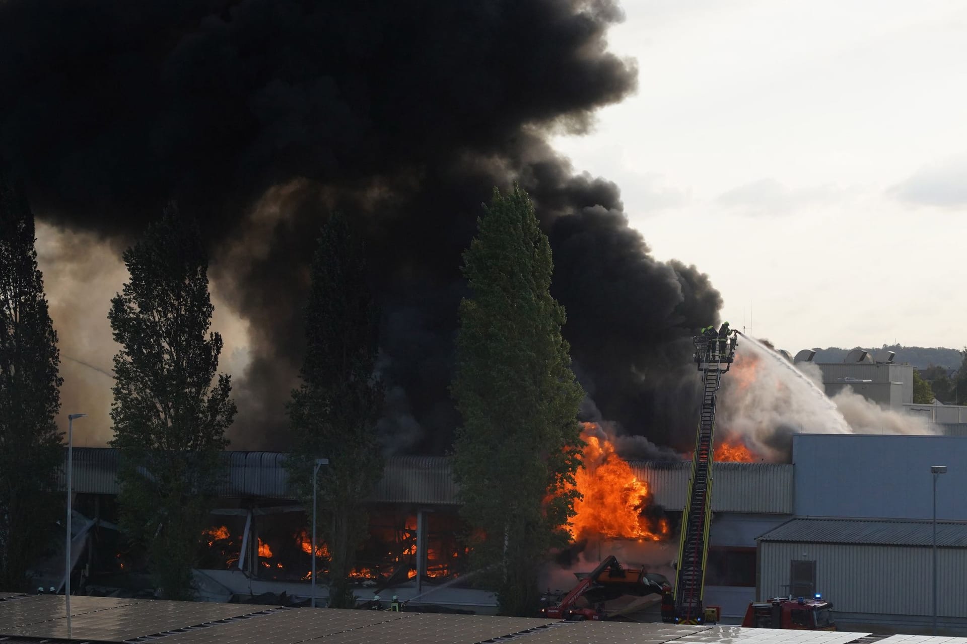 Einsatzkräfte der Feuerwehr löschen einen Brand in Gäufelden: Durch das Feuer ist die Lagerhalle des Fleischereibetriebes einsturzgefährdet.