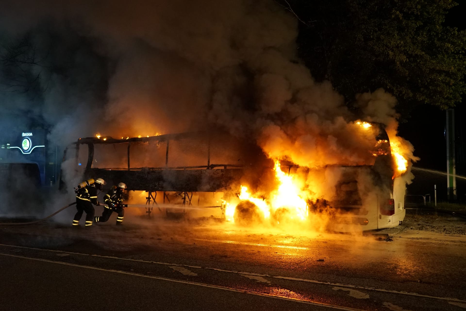 Der in Flammen stehende Bus: Auch mehrere weitere Fahrzeuge wurden beschädigt.