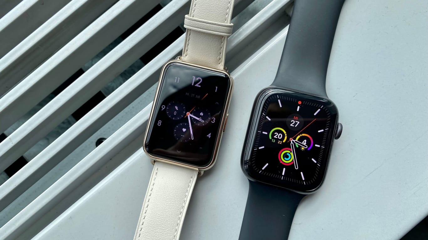 Watch Fit 2 (links) neben der Apple Watch. Bei der Helligkeit des Displays fallen die Unterschiede deutlich auf.